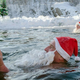 Man dressed as Santa eating ice cream cone in hot spring